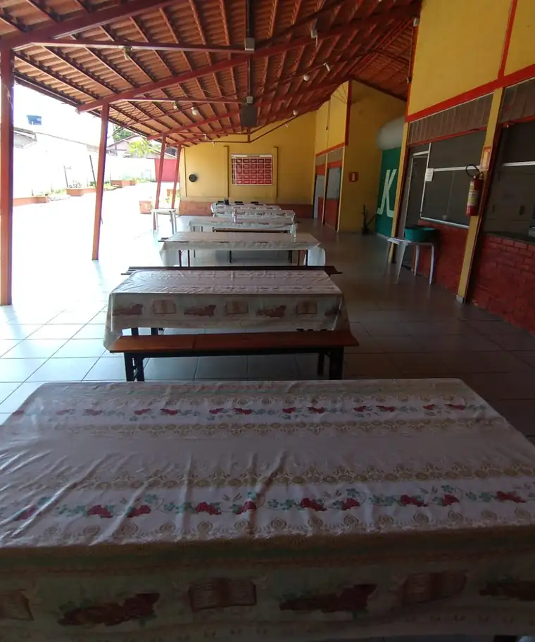 Refeitório coberto da unidade da Clínica Verava, com mesas compridas e toalhas estampadas