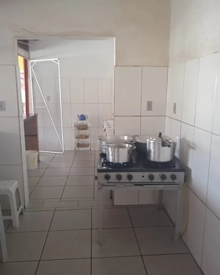 Cozinha azulejada com fogão industrial e panelas