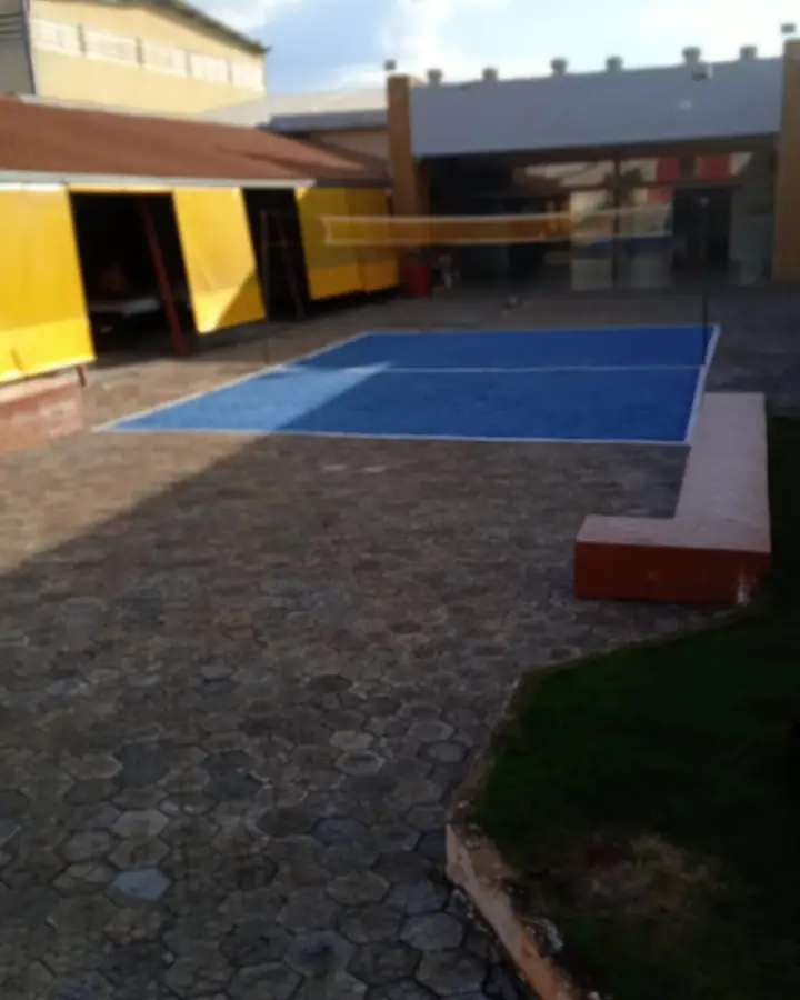 Quadra pintada de azul no pátio calçado da unidade